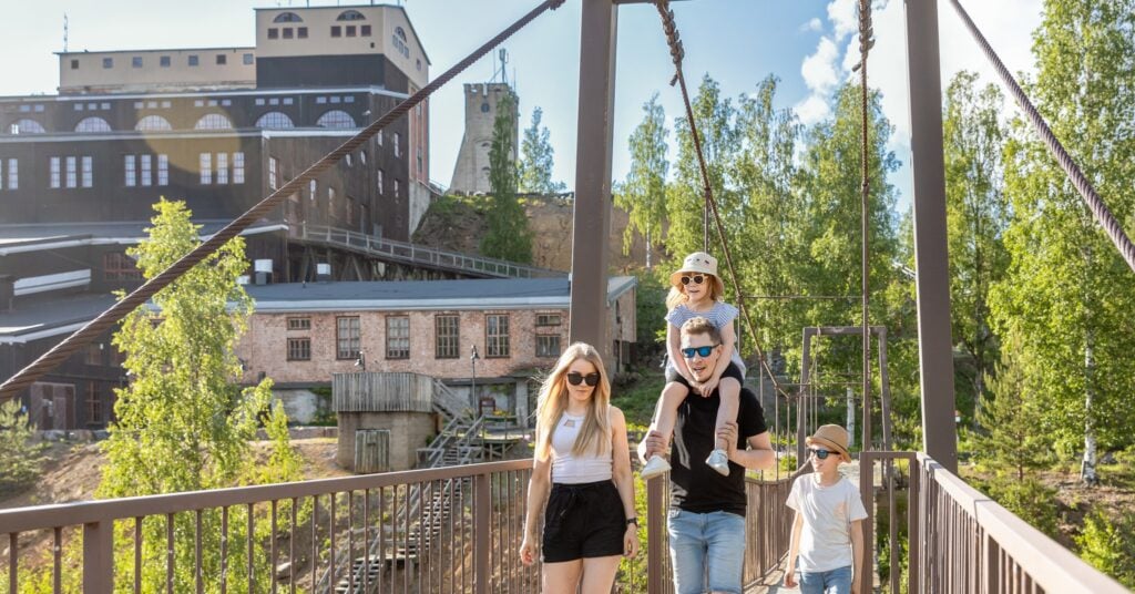 Perhe kulkee Vanhan Kaivoksen riippusiltaa pitkin.