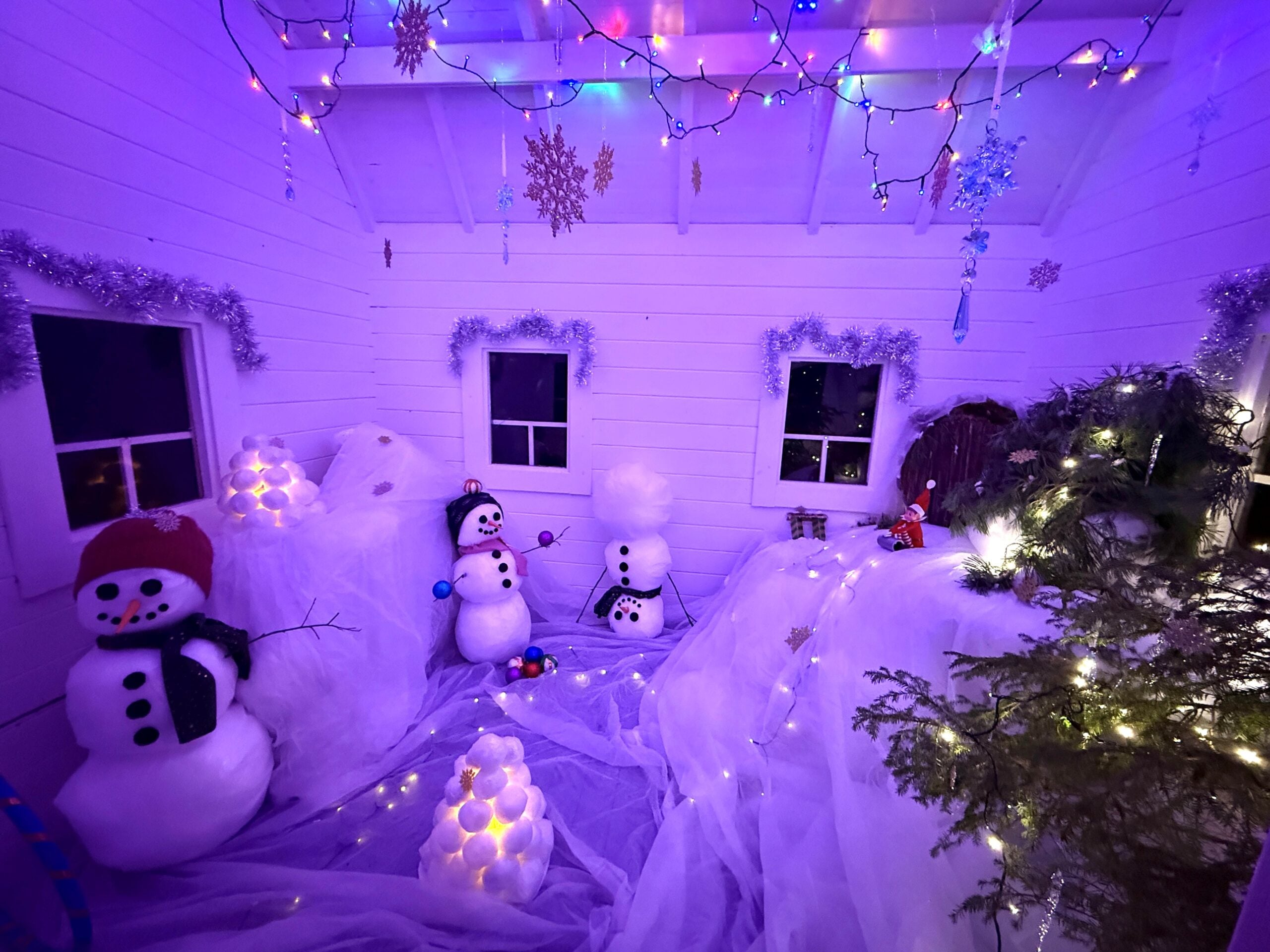 Jouluvaloin ja sadoin pienin yksityiskohdin koristeltu leikkimökkikylä johdattaa kurkisteemaan satujen minimaailmoihin